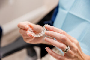 Image of a patient holding a teeth whitening tray.